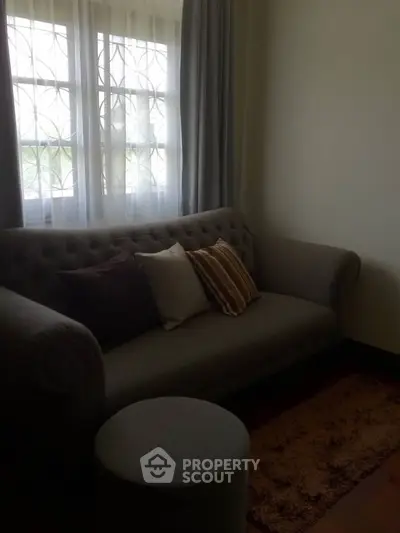 Cozy living room with elegant sofa and natural light from window.