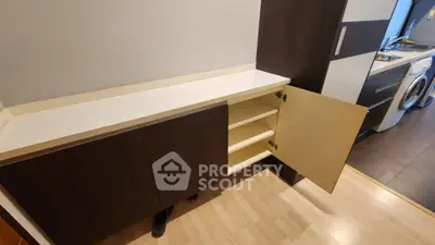 Modern kitchen with open cabinet and washing machine, showcasing sleek design and functionality.