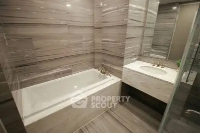Luxurious modern bathroom with elegant marble finishes and built-in bathtub.