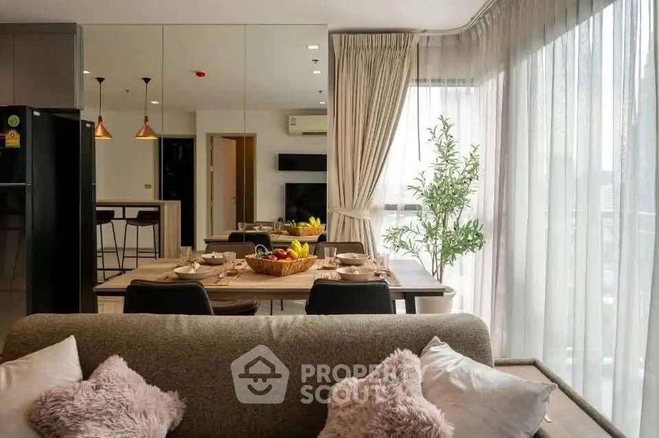 Modern living room with dining area and large windows in a stylish apartment.