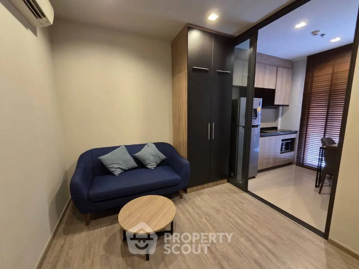Modern living room with cozy sofa and open kitchen layout in stylish apartment.