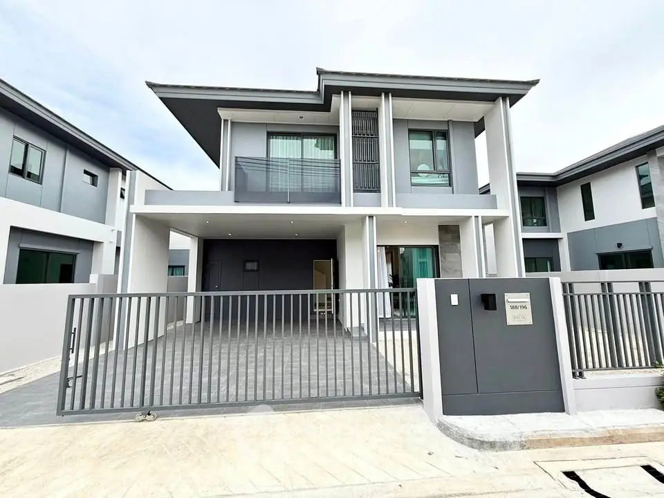 Modern two-story house with sleek design and spacious driveway in a contemporary neighborhood.
