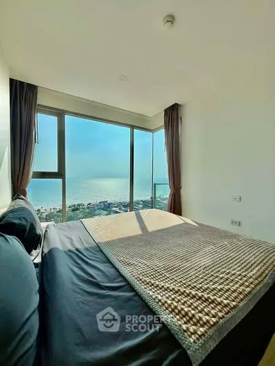Luxurious bedroom with stunning ocean view and floor-to-ceiling windows