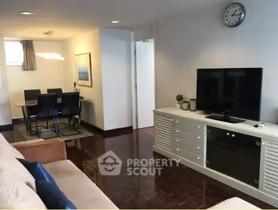 Spacious living room with elegant dining area and modern TV setup, perfect for family gatherings.
