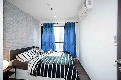 Modern bedroom with stylish decor and large window offering natural light.
