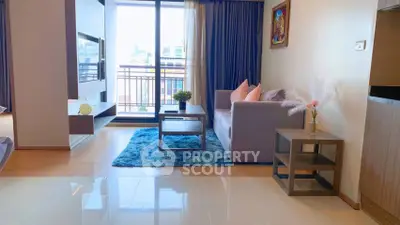 Modern living room with balcony view, stylish decor, and cozy seating area in a bright apartment.