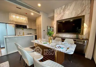 Luxurious modern kitchen and dining area with marble accents and elegant lighting.