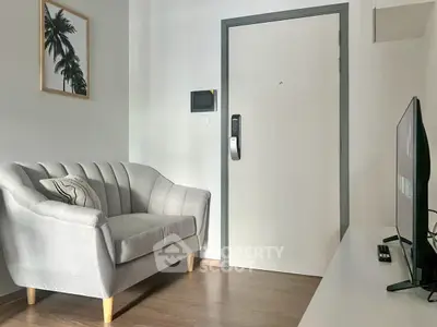 Modern living room with stylish sofa and wall art, featuring sleek TV setup.