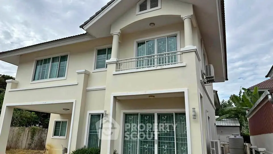 Charming two-story house with elegant facade and lush surroundings, perfect for family living.
