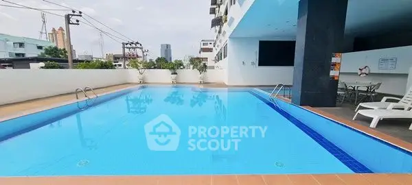 Stunning rooftop pool with city views in modern apartment complex.