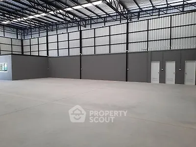 Spacious industrial warehouse interior with high ceilings and ample floor space.