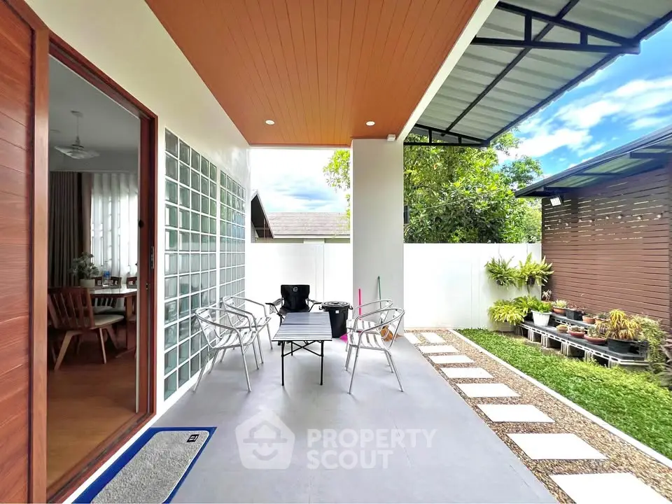 Charming patio with modern outdoor seating and lush garden view, perfect for relaxation and entertaining.