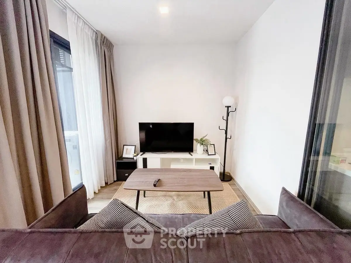 Modern living room with sleek furniture and large TV, perfect for relaxation and entertainment.