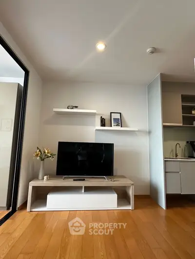 Modern living room with sleek TV stand and open kitchen layout