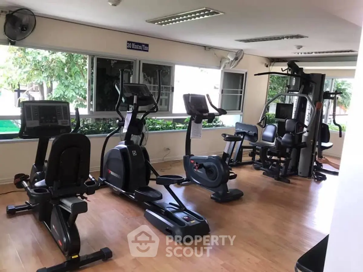 Modern gym with exercise equipment and large windows in a residential building