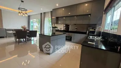 Modern kitchen with sleek cabinetry and open layout, featuring a central island and dining area.
