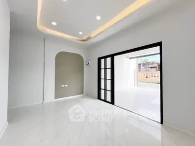 Spacious modern living room with sleek flooring and recessed lighting.