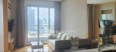 Modern living room with city view, featuring sleek furniture and large windows for natural light.