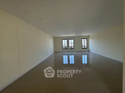 Spacious empty room with large windows and glossy tiled floor, perfect for customization.