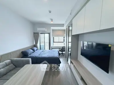 Modern studio apartment with sleek design and city view, featuring a cozy bed and stylish furniture.