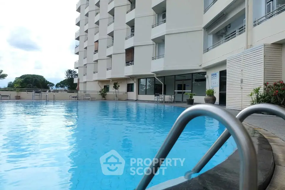 Luxurious apartment building with inviting outdoor pool and modern design.