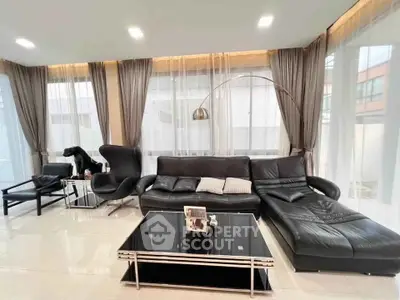 Luxurious modern living room with sleek black leather furniture and elegant decor.
