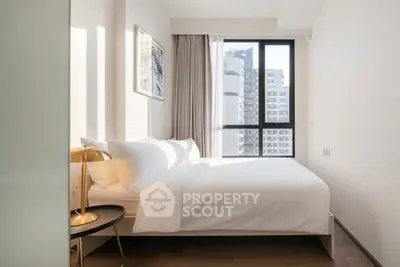 Bright and modern bedroom with city view, featuring elegant decor and natural light.