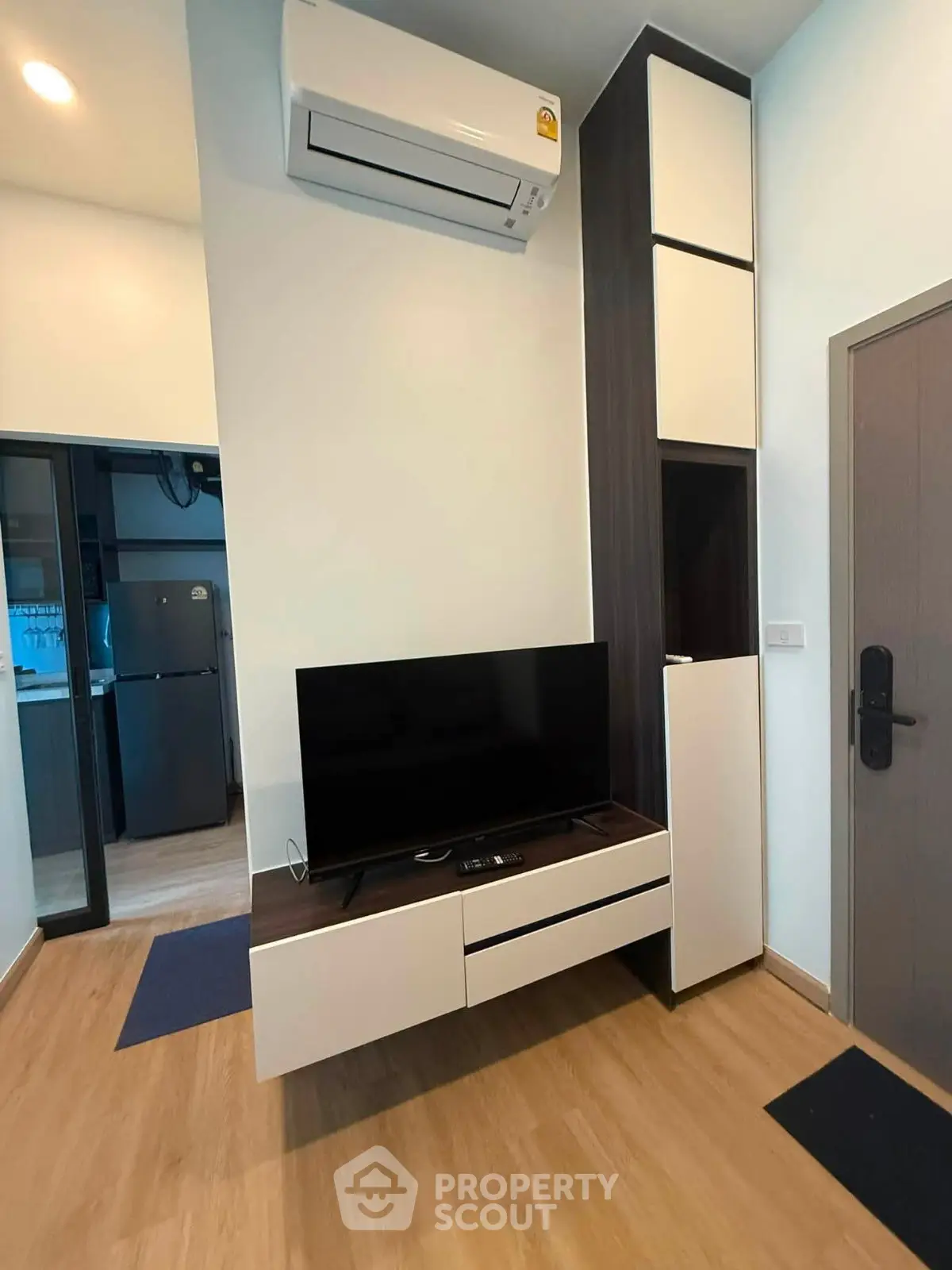 Modern living room with sleek TV stand and air conditioning in stylish apartment.