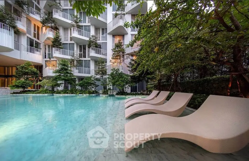 Luxurious apartment complex with serene poolside and modern architecture.