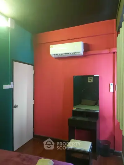 Cozy bedroom with vibrant walls and air conditioning unit