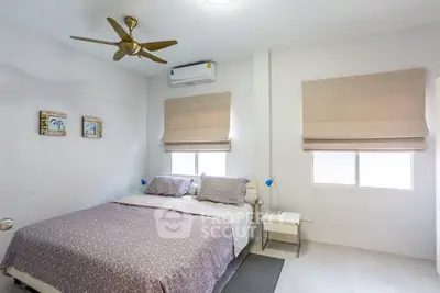 Cozy bedroom with modern decor, featuring a ceiling fan and air conditioning for comfort.
