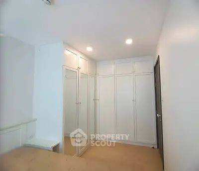 Spacious bedroom with built-in wardrobes and elegant lighting