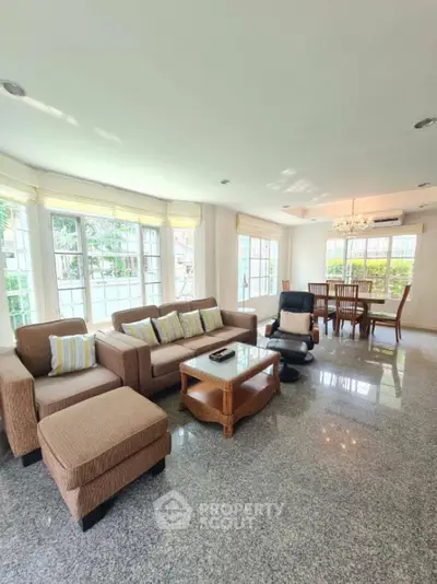 Spacious living room with elegant furniture and large windows offering natural light