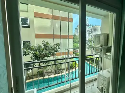 Charming balcony view overlooking lush greenery and modern buildings, perfect for urban living.