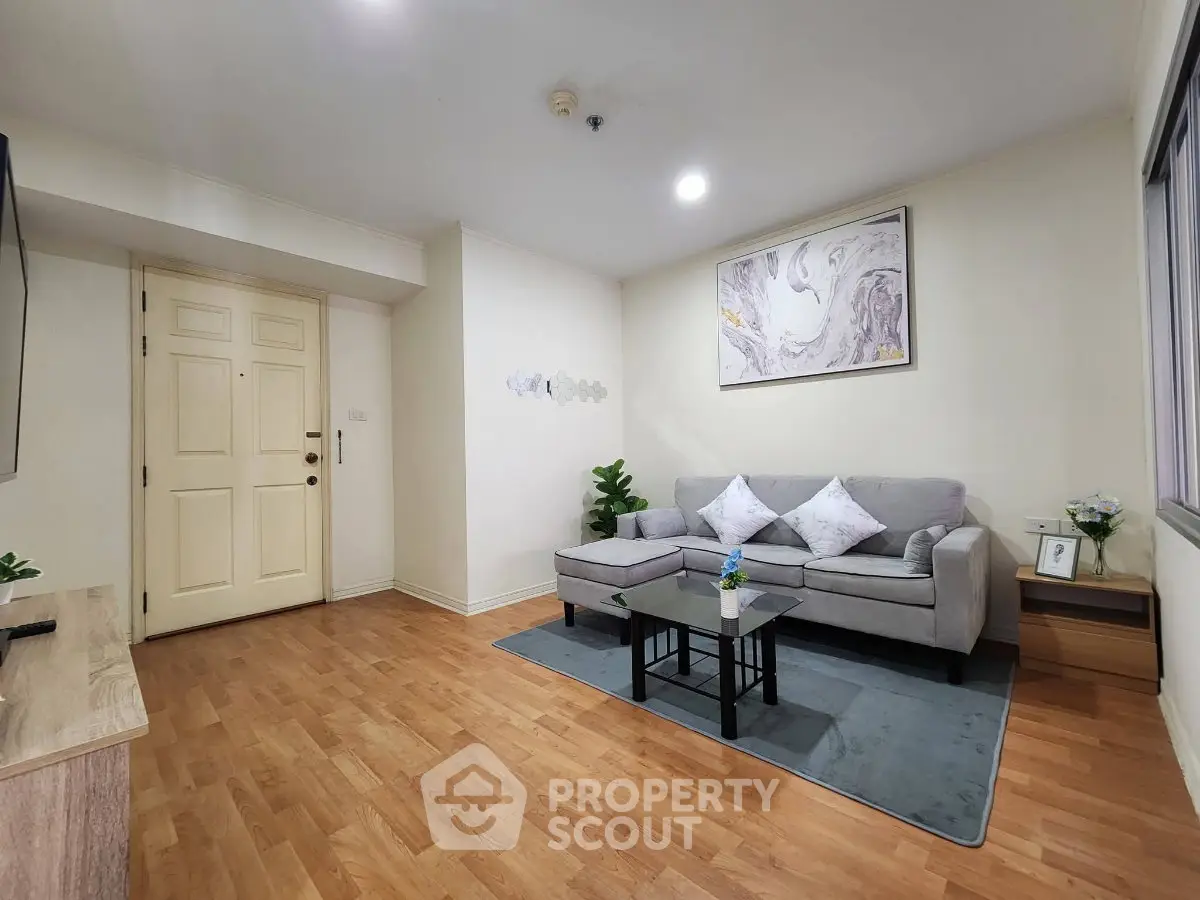 Spacious living room with modern decor and wooden flooring in a cozy apartment.