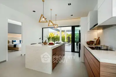 Modern kitchen with open layout and stylish island, leading to a lush garden view.