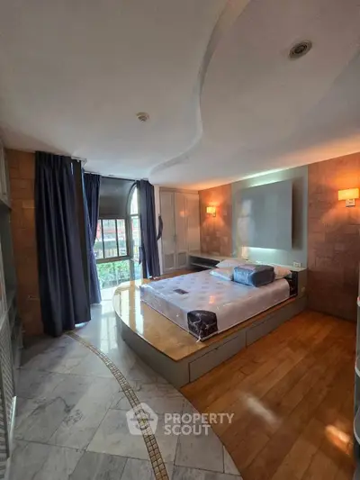 Luxurious bedroom with modern design and large windows offering natural light.