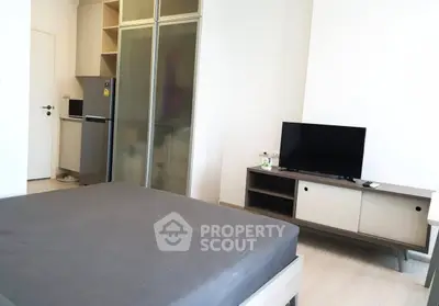 Modern studio apartment with sleek furniture and compact kitchen area.