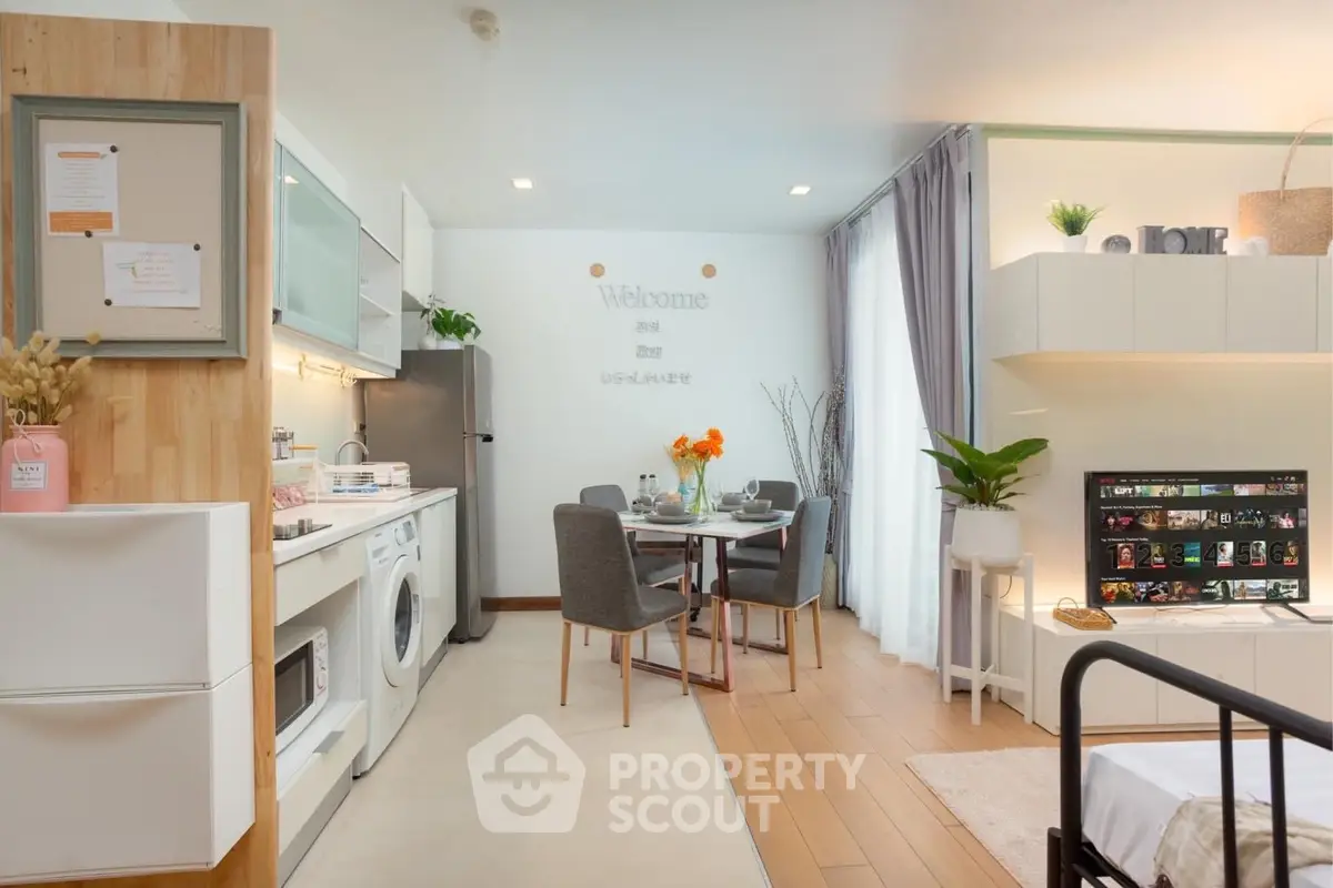 Modern open-plan living room with kitchen and dining area, featuring stylish decor and natural light.