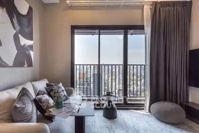 Stylish living room with stunning city view from large windows, modern decor and cozy seating area.