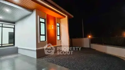 Modern exterior view of a stylish home with sleek lighting and spacious driveway at night.