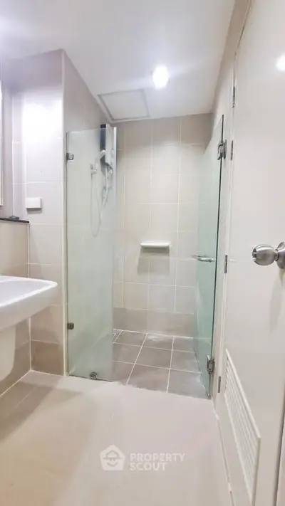 Modern bathroom with glass shower enclosure and sleek fixtures.