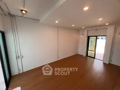 Spacious modern living room with wooden flooring and ample natural light