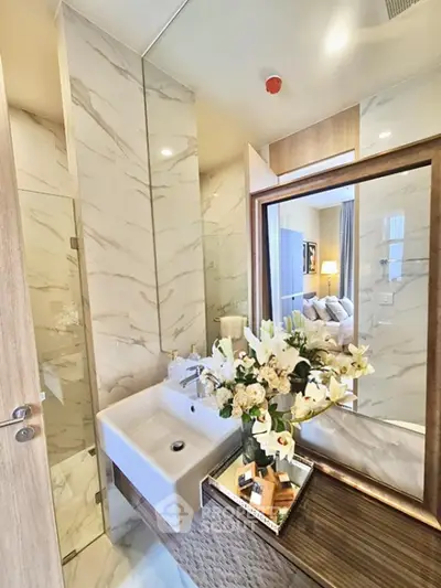 Luxurious bathroom with elegant marble tiles and stylish vanity in modern apartment.