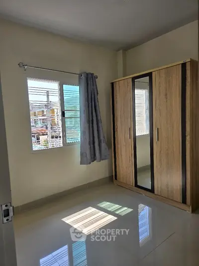 Bright bedroom with large window and modern wardrobe
