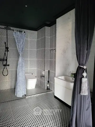 Elegant modern bathroom with stylish black and white tile design and luxurious fixtures.