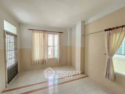 Spacious unfurnished room with tiled floor and large windows, perfect for customization.