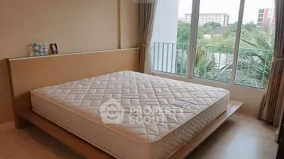 Spacious bedroom with large window offering lush green views, featuring a modern bed and elegant decor.