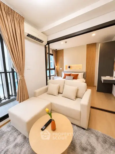 Modern studio apartment with cozy living area and stylish bedroom, featuring elegant decor and natural light.