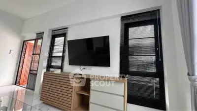Modern living room with sleek TV setup and stylish blinds